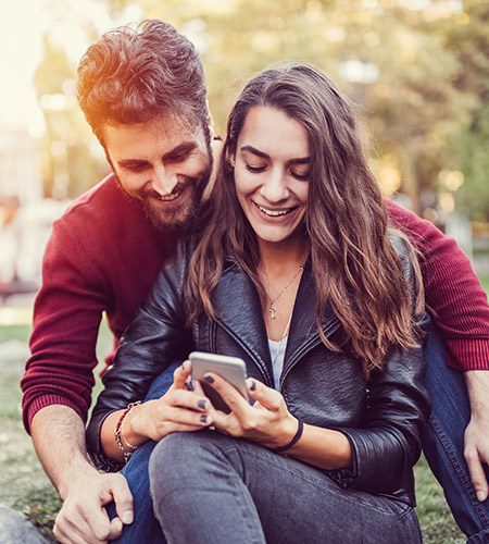 A couple uses the SMI Adviser mobile app at a park.